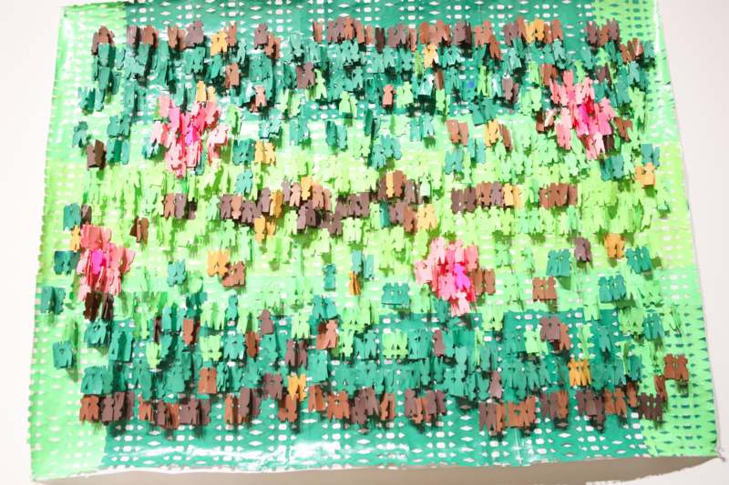 a group of small paper people on a green surface