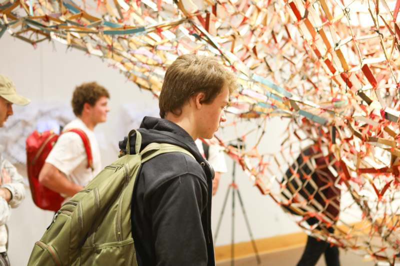a group of people looking at a sculpture