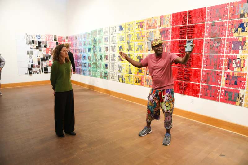 a man standing in front of a wall with pictures