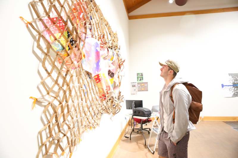a man looking at a wall with a piece of paper