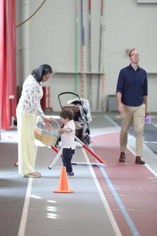 a woman holding a basket and a child walking on a track