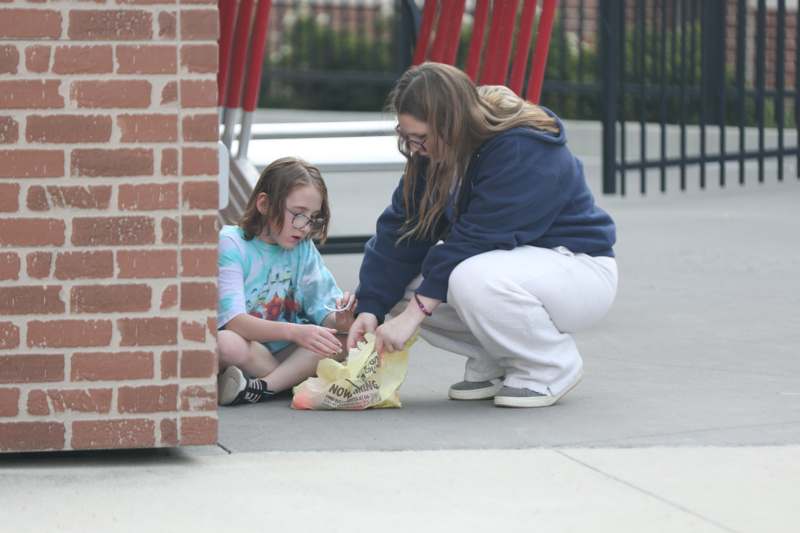 a woman and a girl sitting on the ground