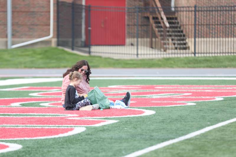a woman and a child sitting on a field