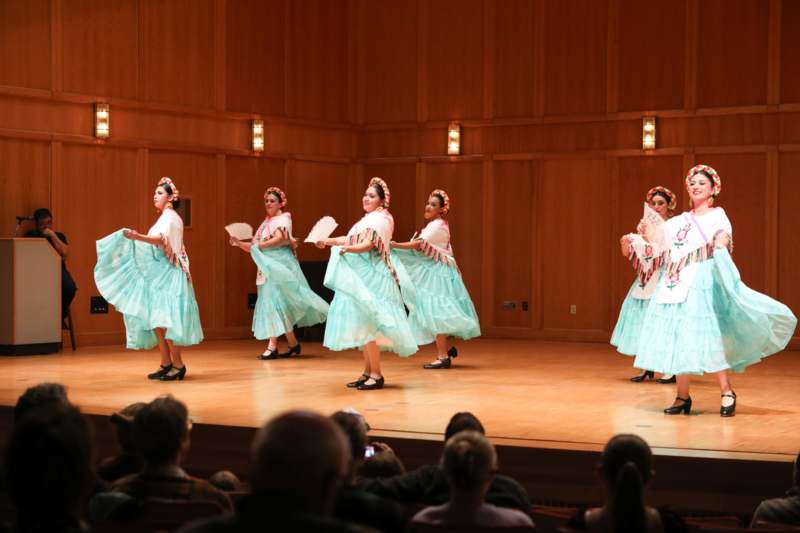 a group of women in blue dresses on a stage