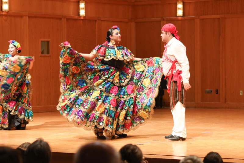 a man and woman in colorful dress on a stage