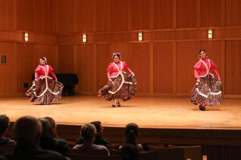 a group of women in dresses on a stage