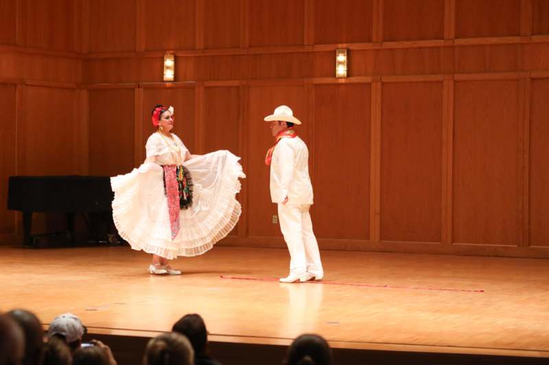 a man and woman in white clothes on a stage