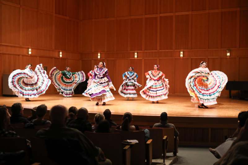 a group of women in colorful dresses on a stage