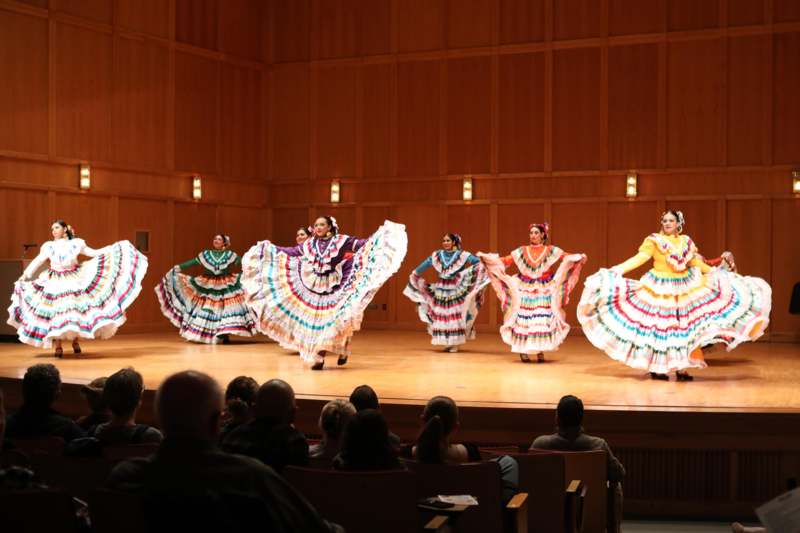 a group of women in colorful dresses on a stage