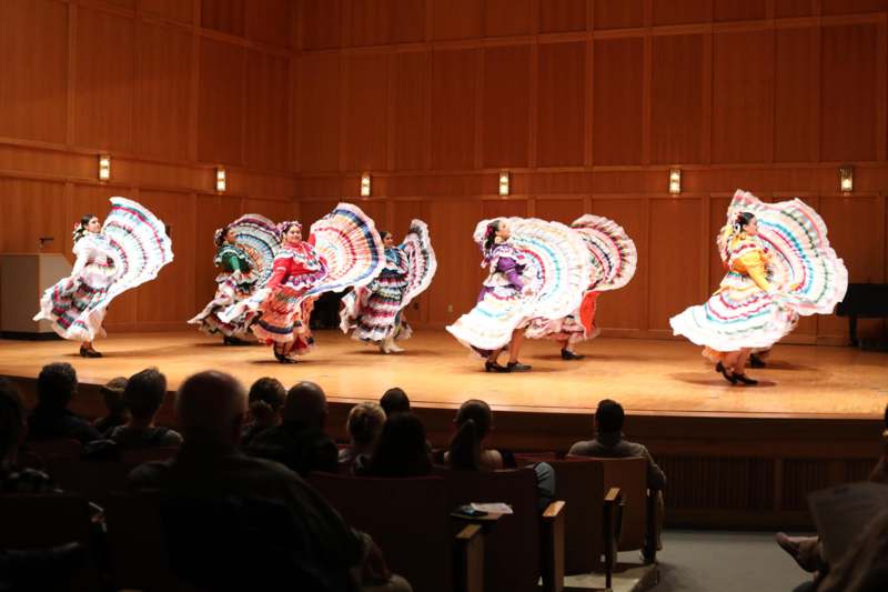 a group of women in colorful dresses on a stage