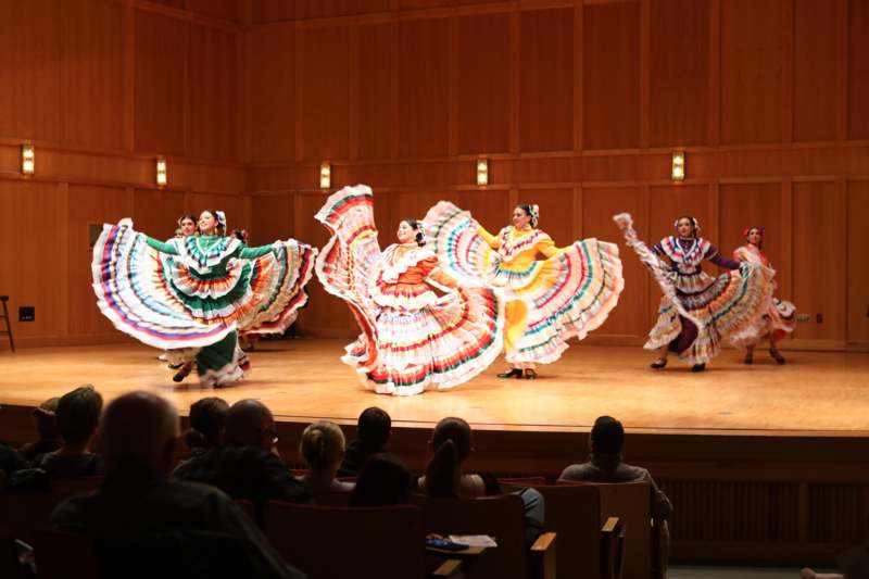 a group of women in colorful dresses on a stage