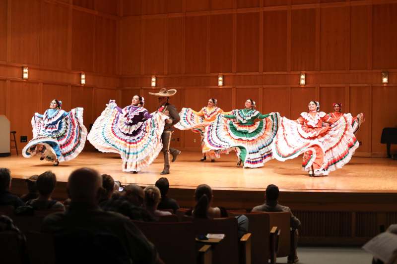 a group of people in colorful clothing on a stage