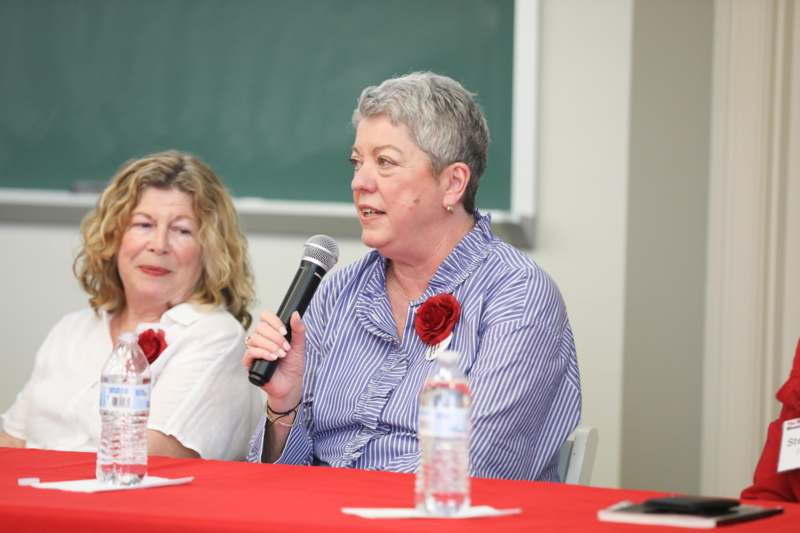 a woman holding a microphone in front of another woman