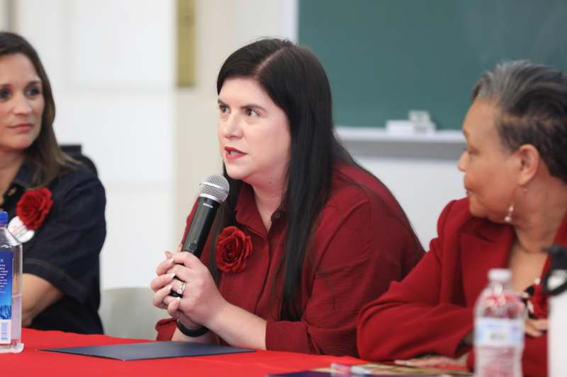 a woman holding a microphone in front of a group of people