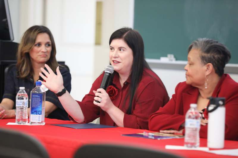 a woman holding a microphone in front of a group of people