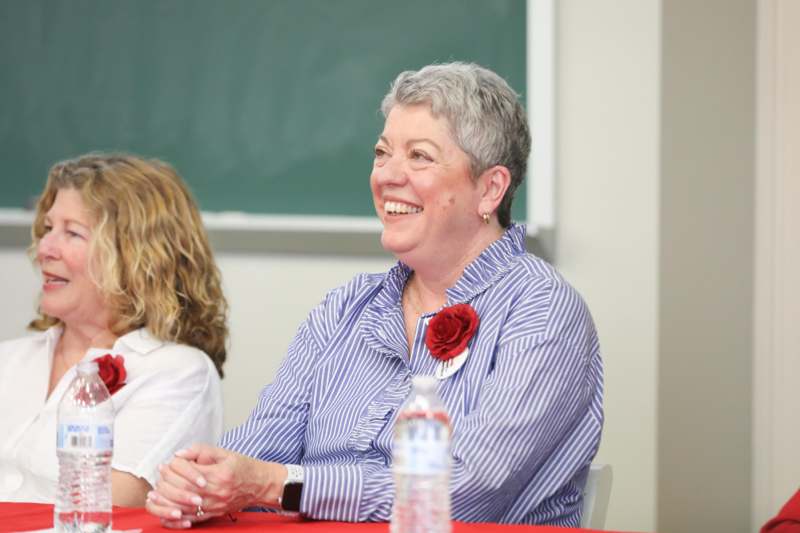 a woman smiling at a table