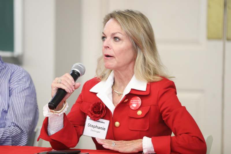 a woman in a red jacket holding a microphone