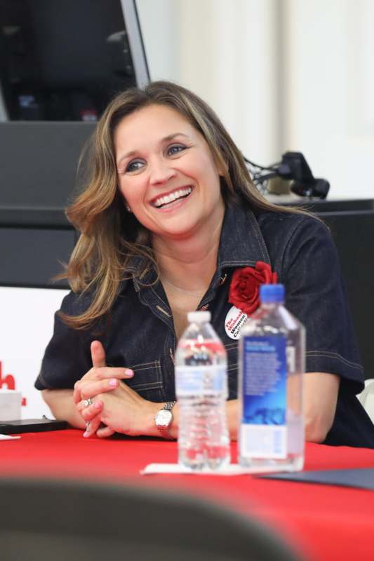 a woman sitting at a table with water bottles