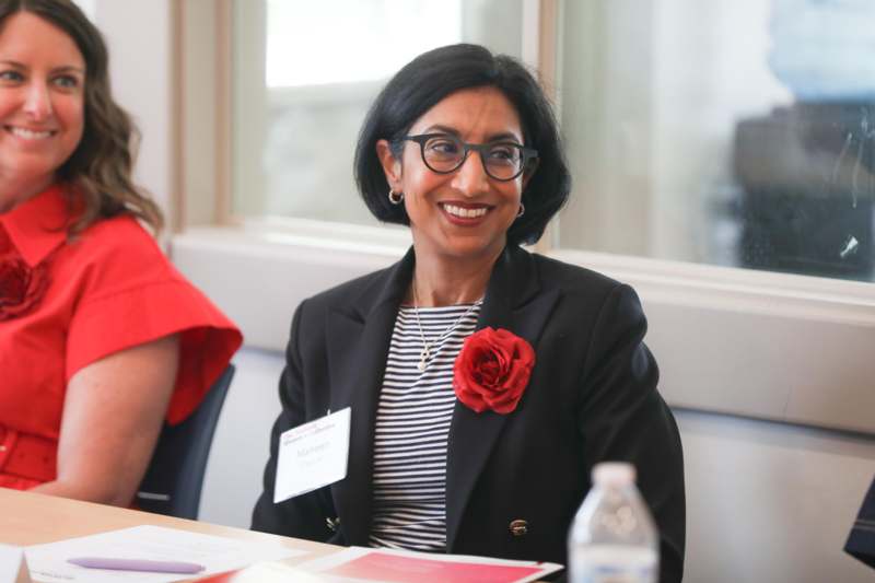 a woman wearing glasses and a badge