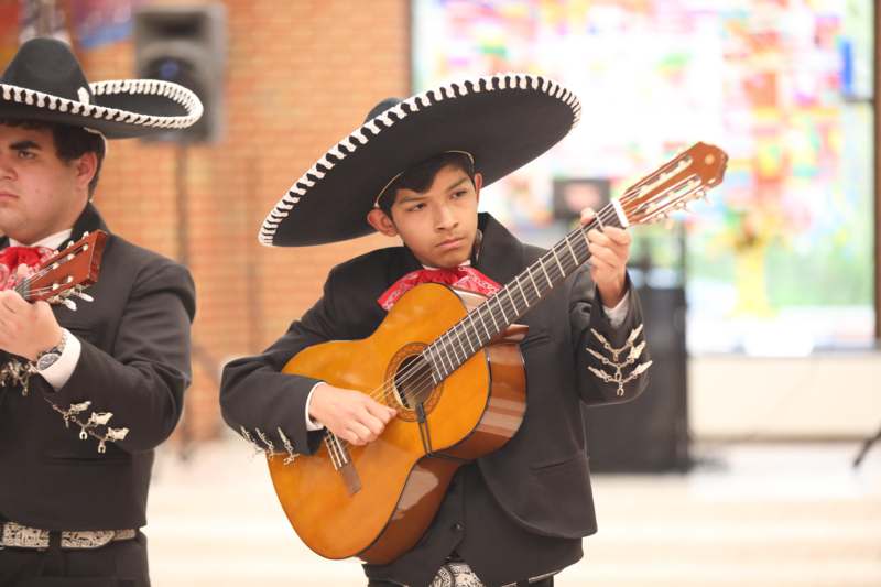 a boy in a sombrero playing a guitar