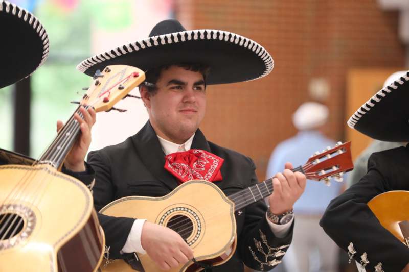a group of men wearing mariachi and a sombrero playing guitars