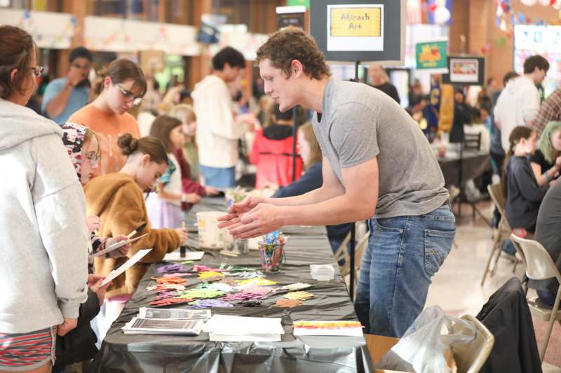 a man standing at a table with people around it