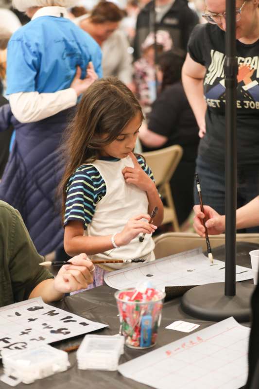 a girl holding a paintbrush and drawing