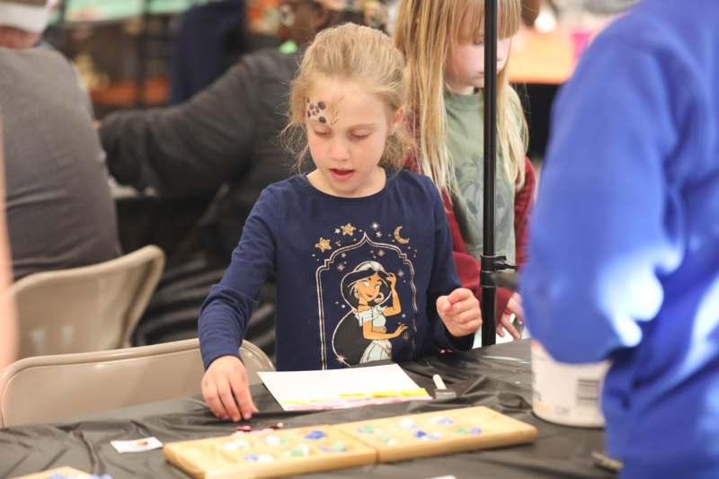 a girl with dots on her face and a piece of paper