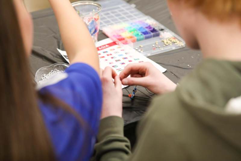 a person and a woman making jewelry