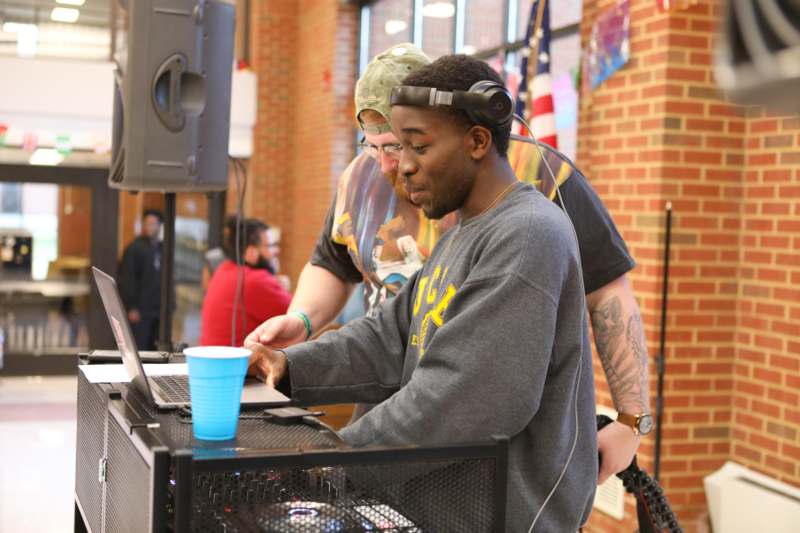a man wearing headphones and looking at a laptop