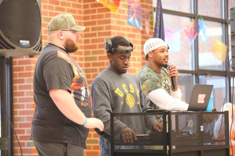 a group of men standing in front of a laptop