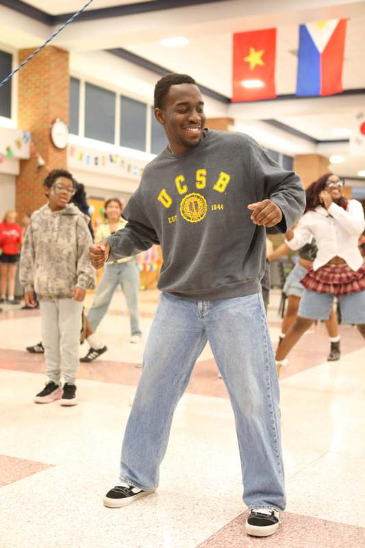 a man dancing in a room with other people