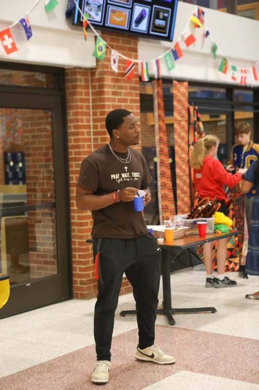 a man standing in a room with a table and a cup