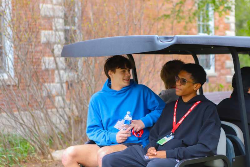 a group of people sitting in a golf cart