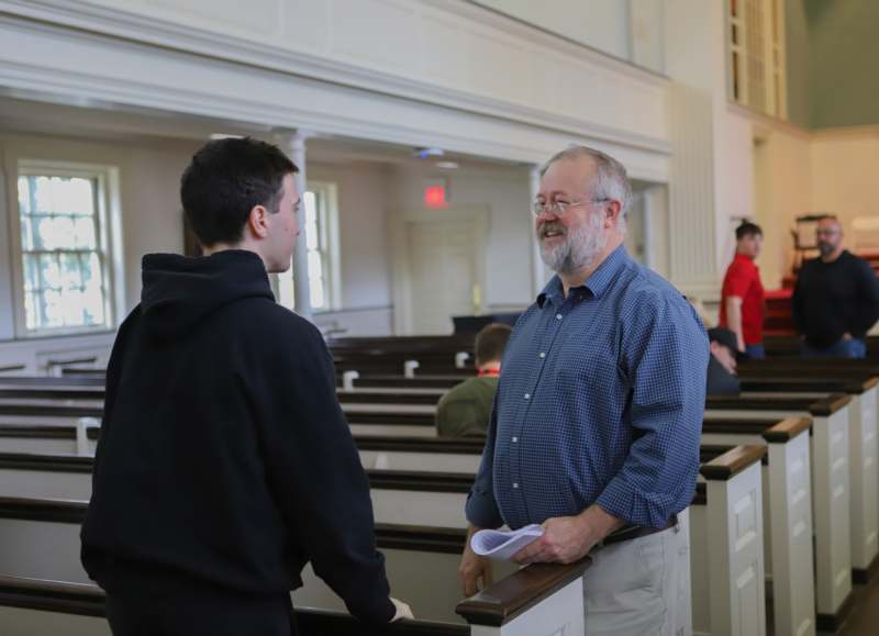 a man talking to a young man in a church