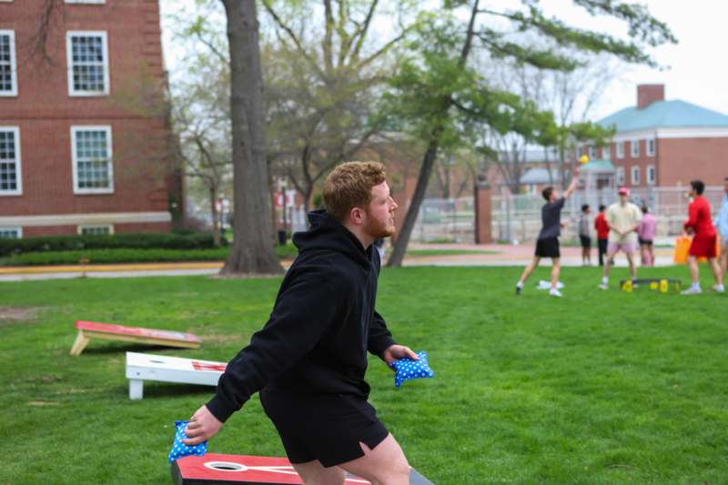 a man throwing bags in a park
