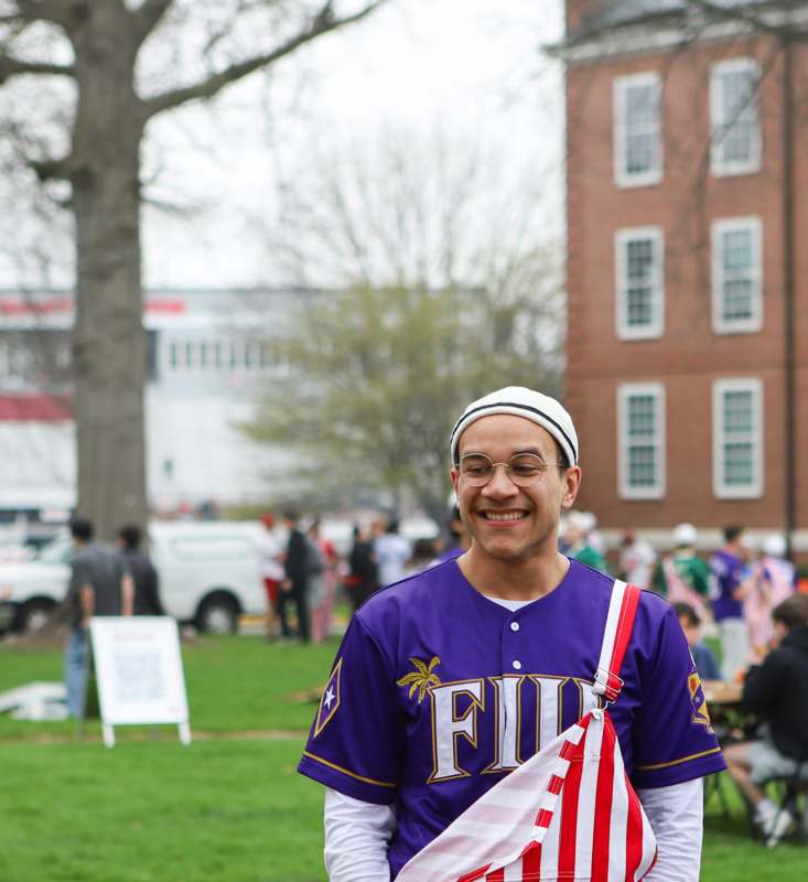 a man wearing glasses and a purple jersey