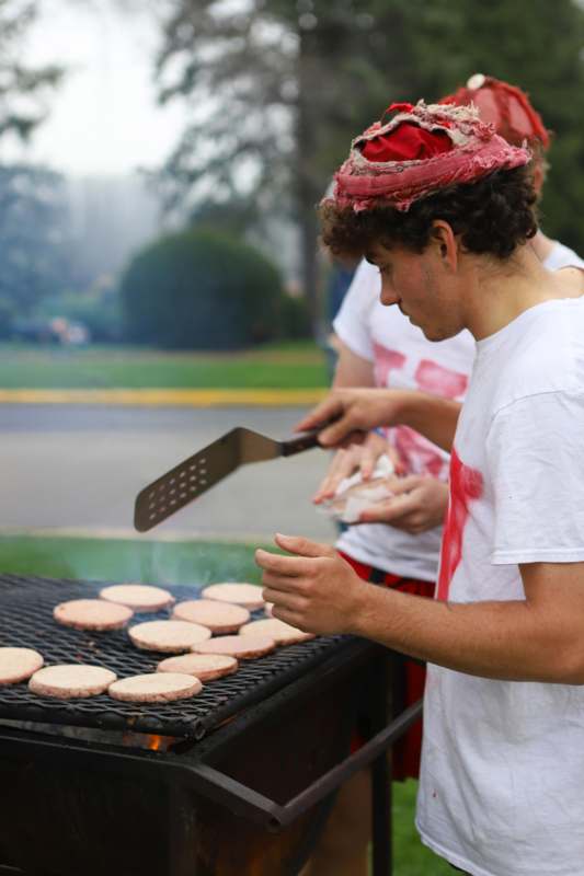 a man cooking burgers on a grill