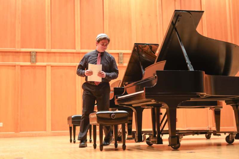 a man standing next to a piano