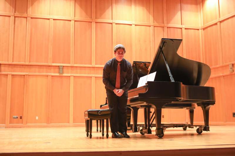 a man standing next to a piano