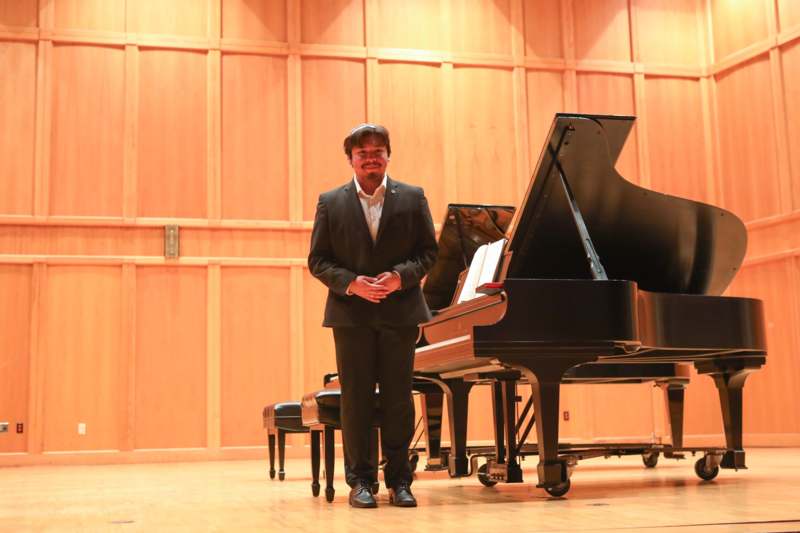 a man standing in front of a piano