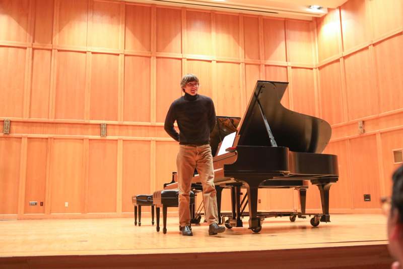 a man standing in front of a grand piano