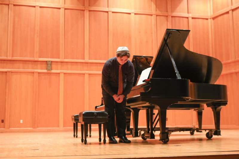 a man standing next to a piano