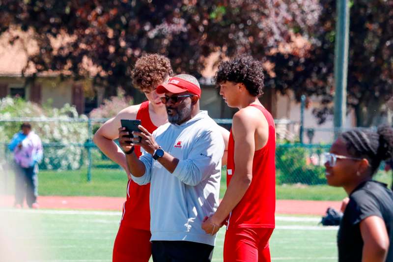 a group of people standing on a field looking at a cellphone