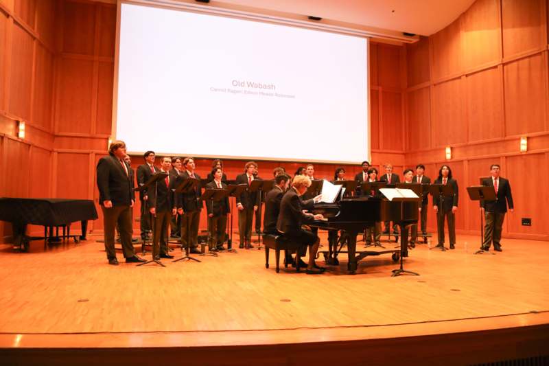 a group of people performing in front of a screen