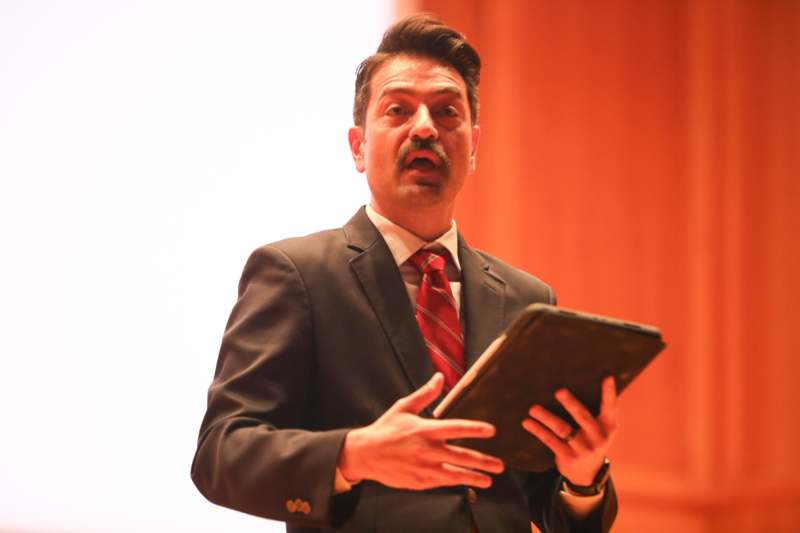 a man in a suit holding a tablet