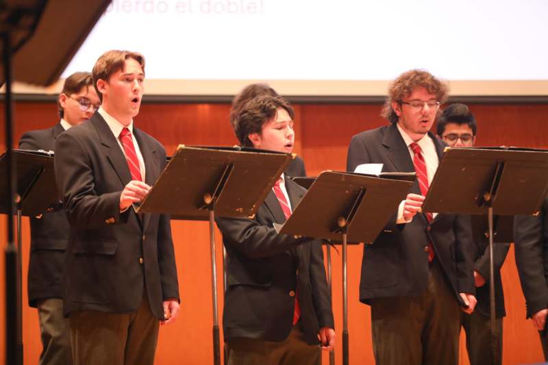 a group of men wearing suits and standing in front of a stage
