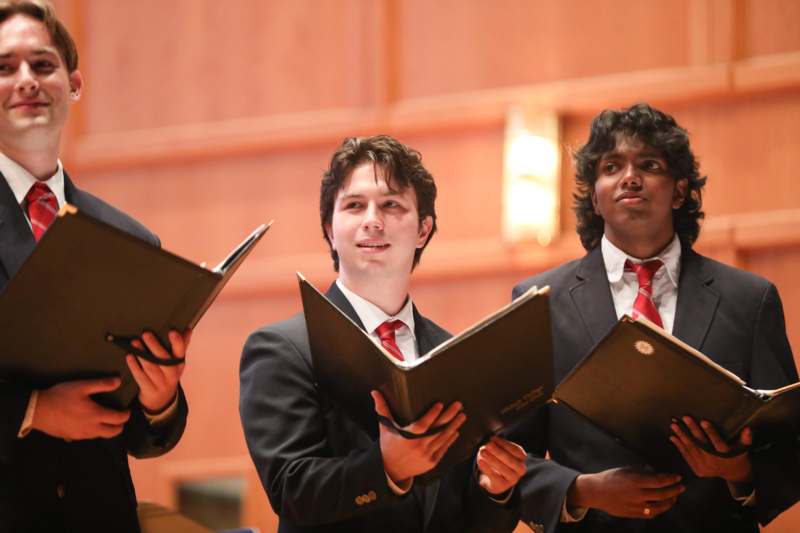 a group of men holding folders