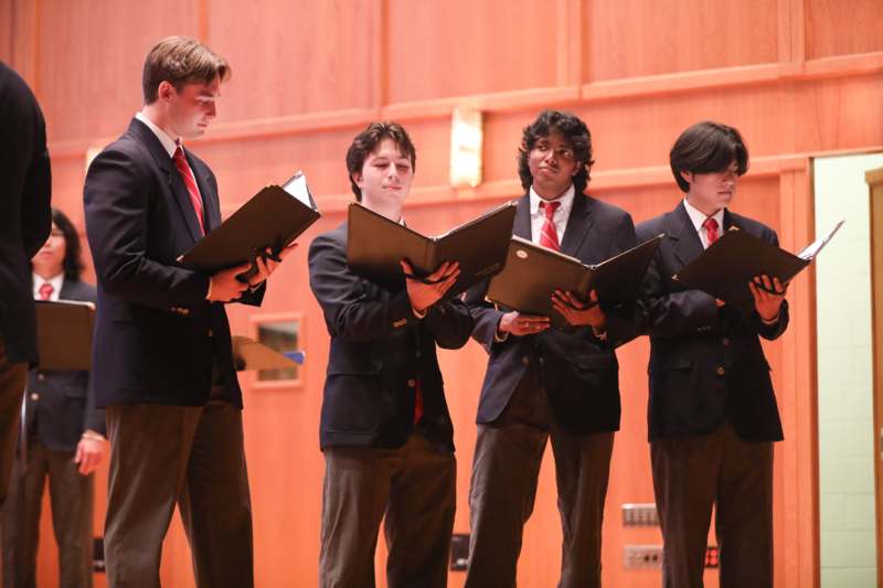 a group of men in suits holding folders