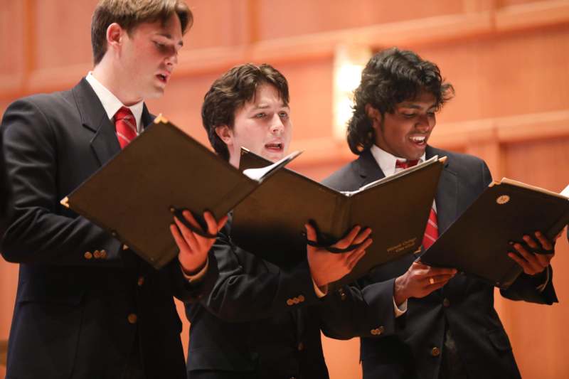 a group of men singing in a choir